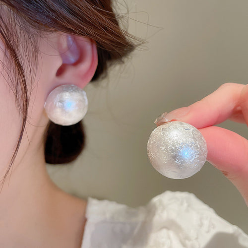 Styled close-up of textured silver tone ball studs