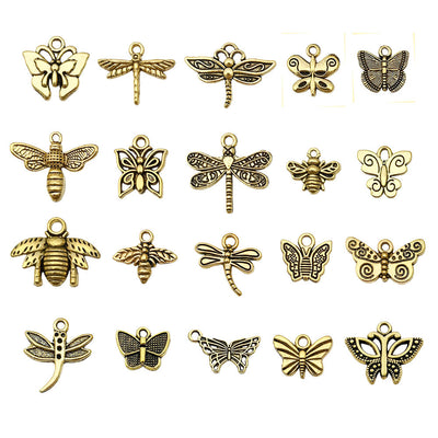 Matte gold-tone butterfly and dragonfly charms arranged on a light background