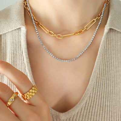 Layered gold paperclip and crystal tennis necklace on beige top