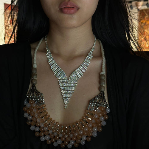 Silver V rhinestone necklace worn layered over beaded statement necklace