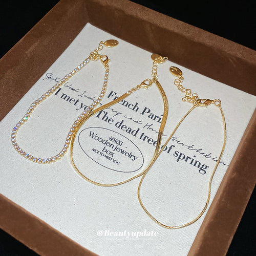 three-piece crystal tennis and snake-chain bracelet set in gold-tone or silver-tone finishes shown worn in a styled seco