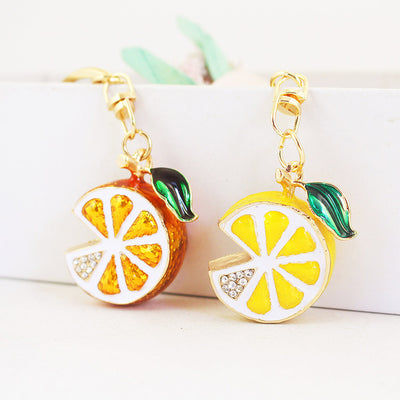 Orange and yellow citrus slice charms displayed side by side.