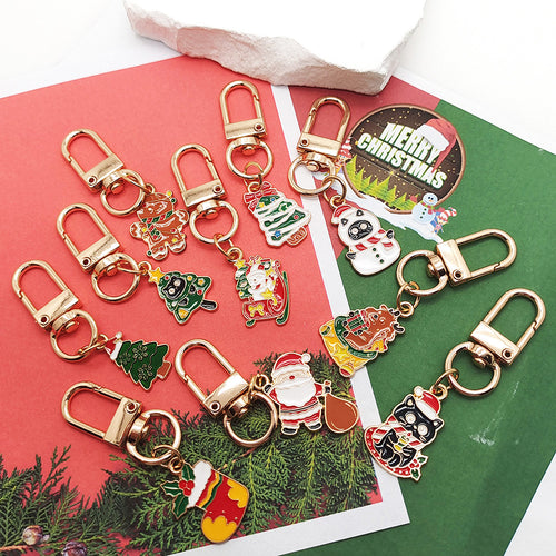 Assorted Christmas enamel keychains with gold lobster clasps on red green paper