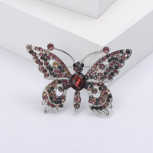Angled display of the dimensional butterfly brooch on a white surface