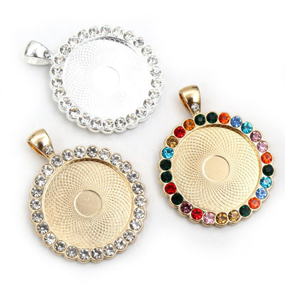 Round cabochon pendant tray bordered with clear or multicolor rhinestones in a group view on a white background