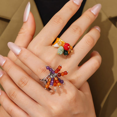 Gold stone cluster and steel bead burst rings worn on hands