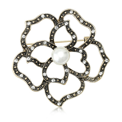 Front view of the openwork crystal flower brooch with pearl center decorative clothing pin on a white background