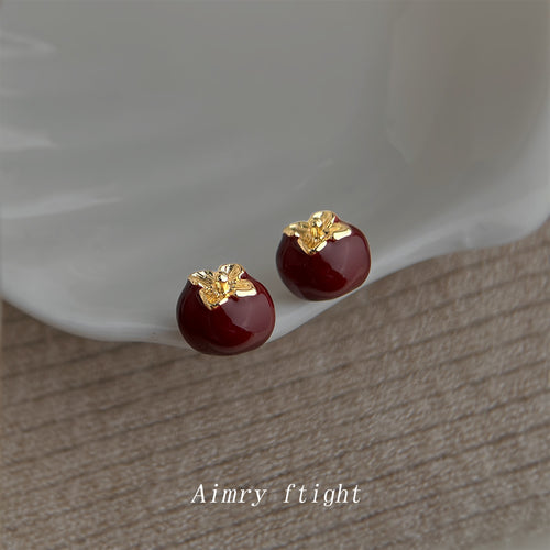 Wine red enamel persimmon studs on white ceramic dish
