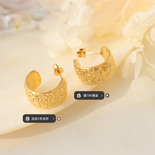 Pair of gold embossed C-hoops on tray with plating and style labels