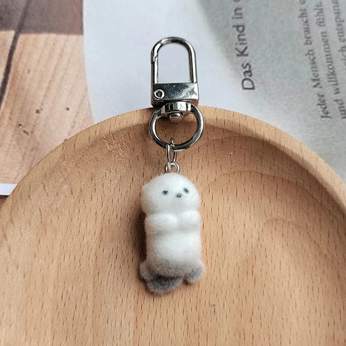 White flocked otter keychain hanging from silver lobster clasp