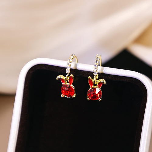 Pair of red bunny rabbit huggies displayed on black and white jewelry stand