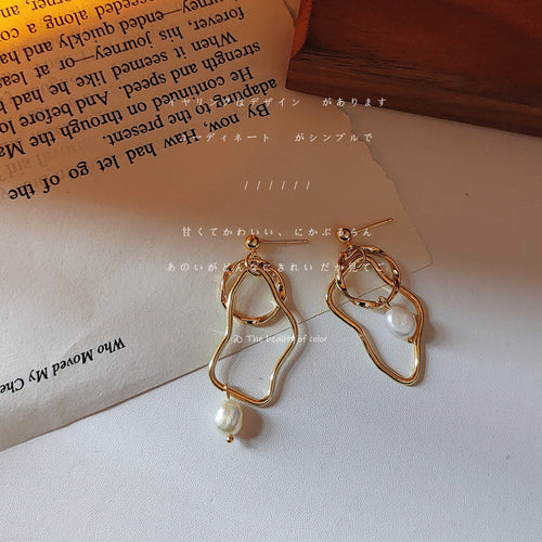 Gold-tone irregular-double-loop pearl asymmetric studs in the first product display.