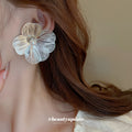 Silver Tone Sculpted Flower Stud Earrings with Polished Metal Accents view 3