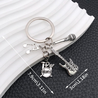 Front display of silver tone guitar drum and microphone keychain with visible colors and attached hardware