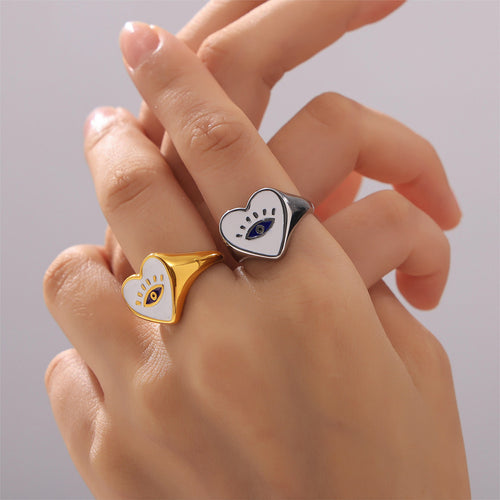 Gold and steel heart evil eye signet rings worn on two fingers