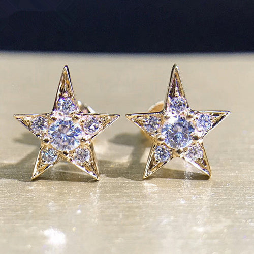 Pair of gold tone crystal five-point star stud earrings close-up