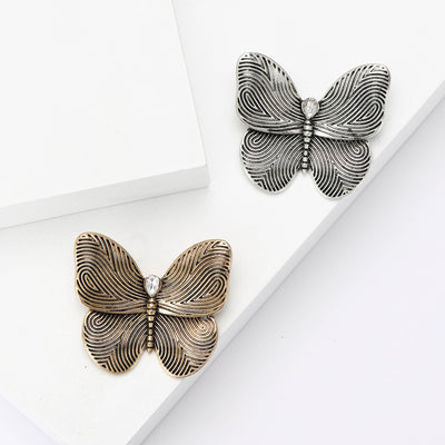 Silver and gold textured butterfly brooches together