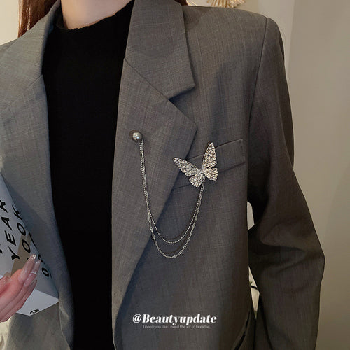 silver-tone butterfly double-chain brooch with a gray pearl-like pin shown in the first close product view