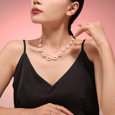 Model wearing pearl flower gold bar necklace with black top