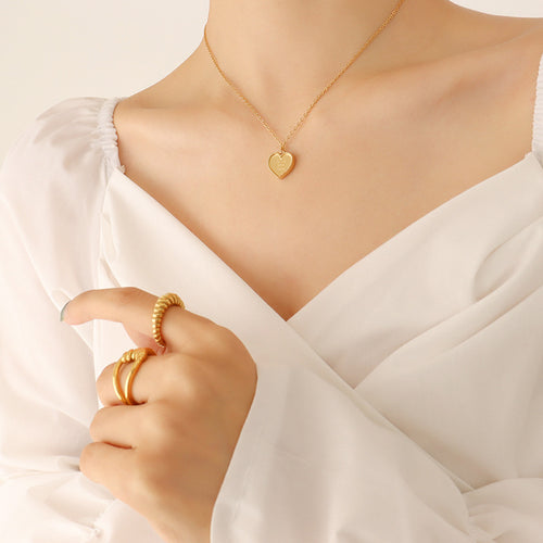 Close collarbone view of gold heart pendant on cable chain