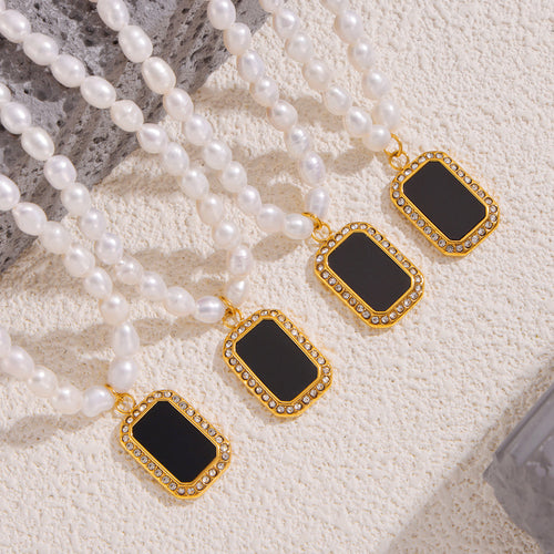 Four pearl strands with black rectangular rhinestone pendants on sand