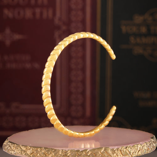 Gold open cuff standing upright showing C shape