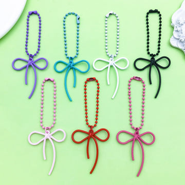 Butterfly Charm Keychains Featuring Magenta Bow Across 17 Pictured Variations