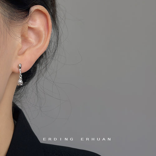 Silver pearl cup drop earring worn on ear side view