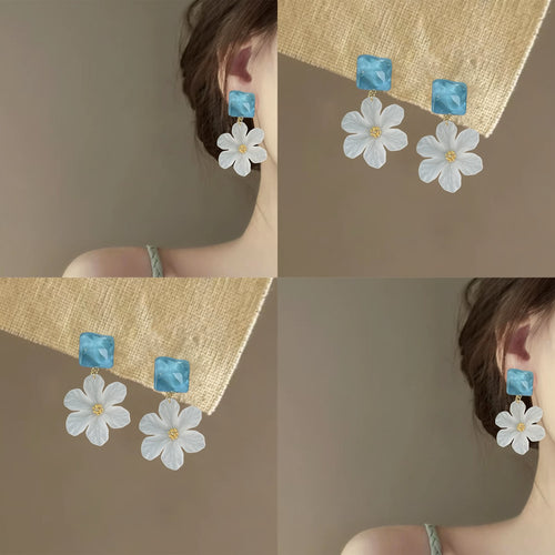 Product close-up of 蓝白方形花朵耳钉 showing marbled blue square tops with lightweight white daisy-shaped drops