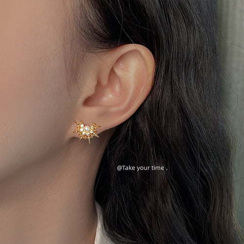 Gold sunburst pearl stud worn on ear side profile close-up