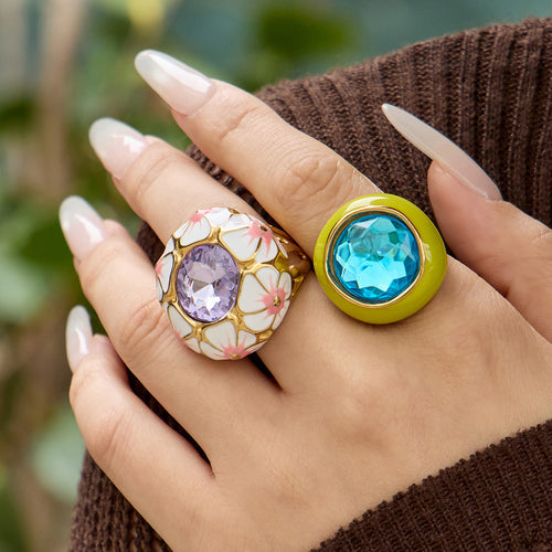 Styled hand view of enamel and faceted glass statement rings in main image 2.
