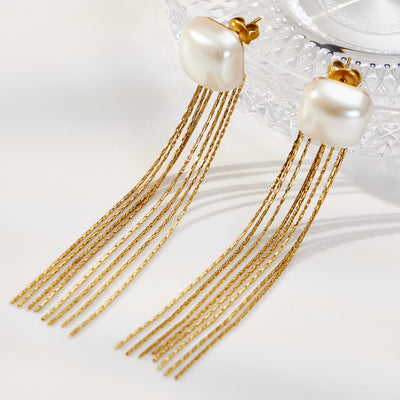 Gold shell bead multi-chain tassel drop earrings on glass dish